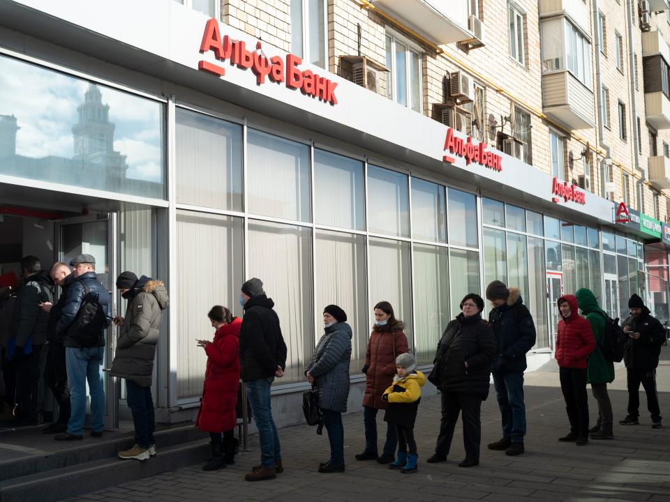 People stand in line to withdraw money from an ATM of Alfa Bank in Moscow, Russia, Sunday, Feb. 27, 2022.