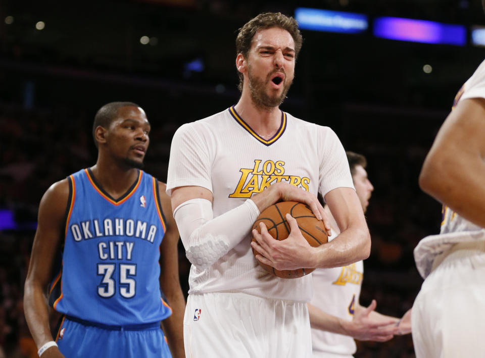 Los Angeles Lakers center Pau Gasol, center, reacts after a foul was called against teammate Ryan Kelley, rear right, as Oklahoma City Thunder small forward Kevin Durant, left, looks on during the first half of an NBA basketball game in Los Angeles, Sunday, March 9, 2014. (AP Photo/Danny Moloshok)