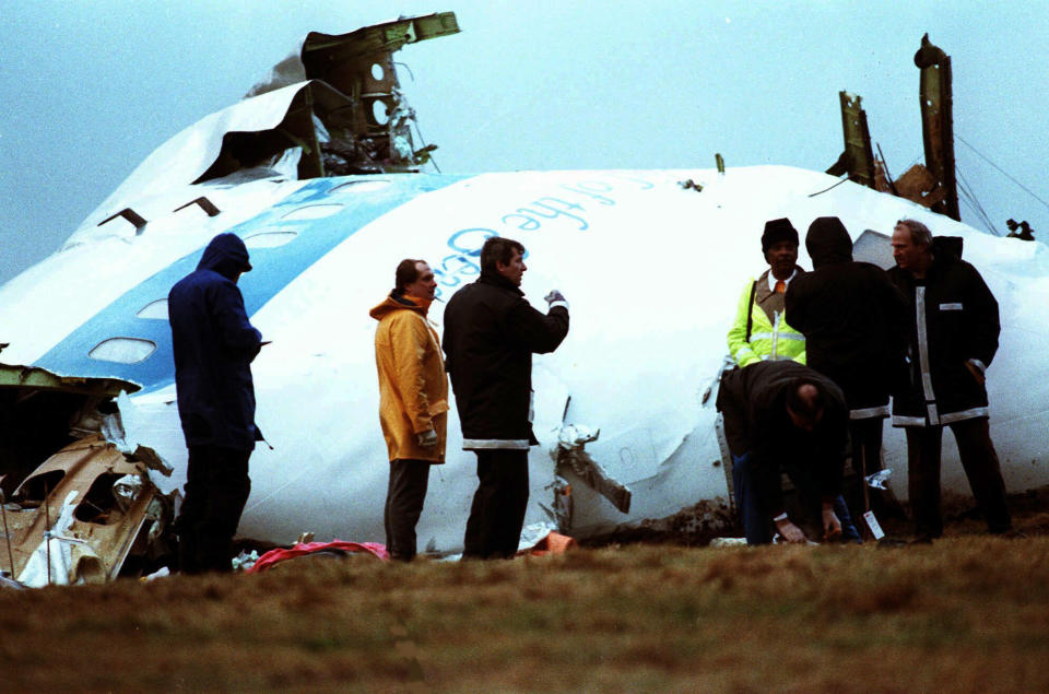 FILE - Unidentified crash investigators inspect the nose section of the crashed Pan Am flight 103, a Boeing 747 airliner in a field near Lockerbie, Scotland, Dec. 23, 1988. U.S. and Scottish authorities said Sunday, Dec. 11, 2022 that the Libyan man suspected of making the bomb that destroyed a passenger plane over Lockerbie, Scotland, in 1988 is in U.S. custody. (AP Photo/Dave Caulkin, File)