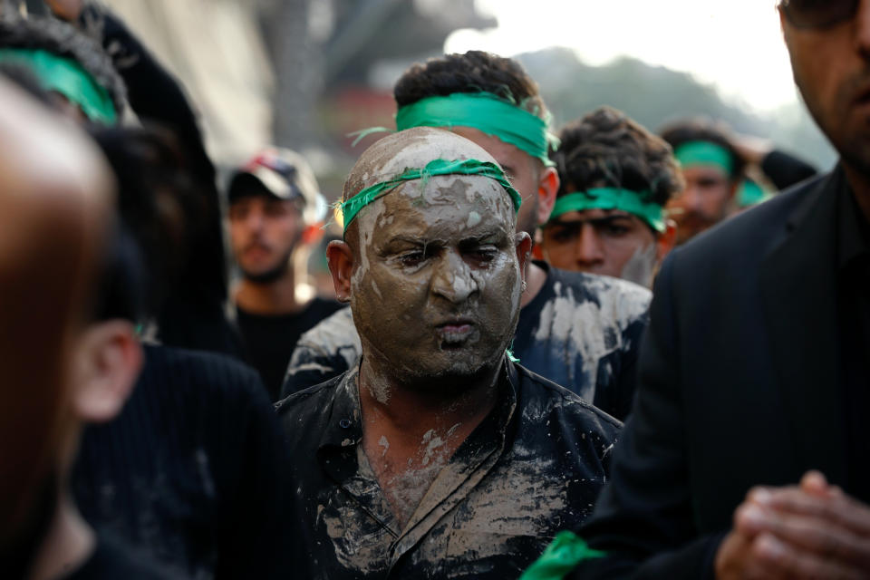 Shiite faithful pilgrims cover themselves with mud as a sign of grief at the golden-domed shrine of Imam Moussa al-Kadhim, who died at the end of the 8th century, during the annual commemoration of his death, in Baghdad, Iraq, Wednesday, March 10, 2021. (AP Photo/Hadi Mizban)