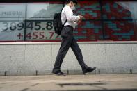 A person walks in front of an electronic stock board showing Japan's Nikkei 225 index at a securities firm Thursday, June 6, 2024, in Tokyo. (AP Photo/Eugene Hoshiko)