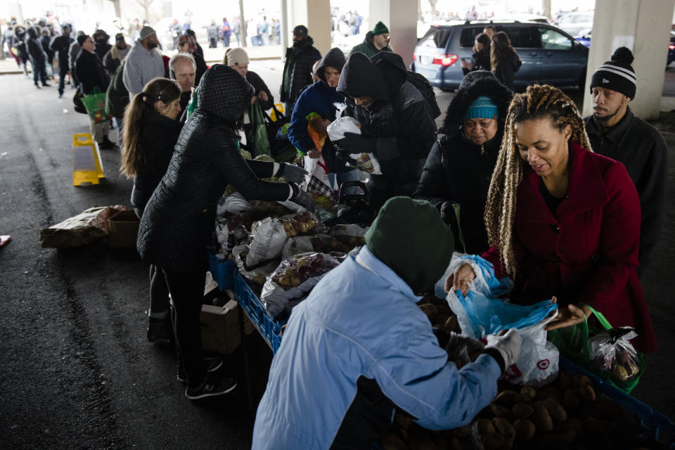 Philabundance volunteers distribute food to furloughed federal workers and their families who are affected by the partial government shutdown, under Interstate 95 in Philadelphia, Wednesday, Jan. 23, 2019. (AP Photo/Matt Rourke)