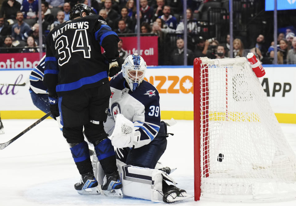 Toronto Maple Leafs forward Auston Matthews (34) scores on Winnipeg Jets goaltender Laurent Brossoit (39) during overtime of an NHL hockey game Wednesday, Jan. 24, 2024, in Toronto. (Nathan Denette/The Canadian Press via AP)