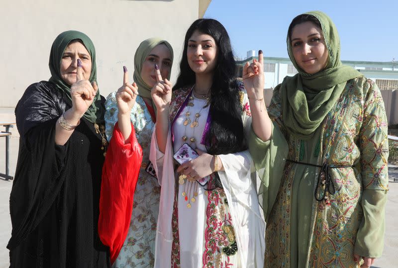 Kurdish women show their ink-stained fingers after casting votes during Iraq's provincial council elections, at a polling station in Kirkuk