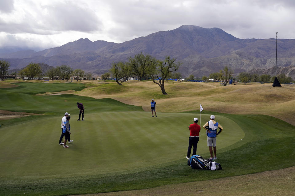 Tony Finau, top left, putts on the first hole during the third round of The American Express golf tournament on the Pete Dye Stadium Course at PGA West Saturday, Jan. 23, 2021, in La Quinta, Calif. (AP Photo/Marcio Jose Sanchez)