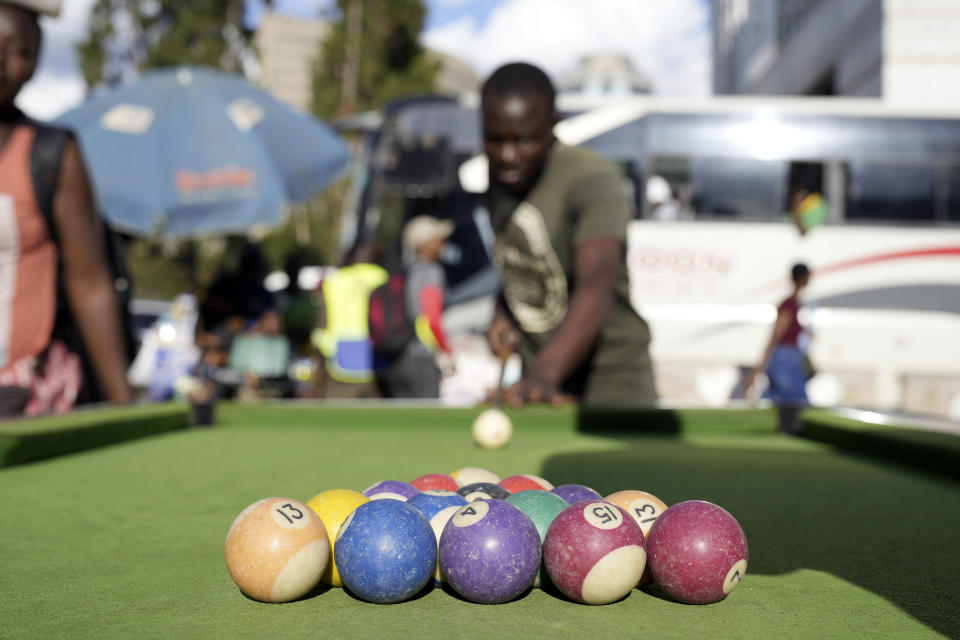 People play pool in an open space in Harare, Zimbabwe, Wednesday, Nov. 30, 2022. Previously a minority and elite sport in Zimbabwe, the game has increased in popularity over the years, first as a pastime and now as a survival mode for many in a country where employment is hard to come by. (AP Photo/Tsvangirayi Mukwazhi)