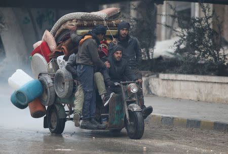 Men ride a tricycle as they flee deeper into the remaining rebel-held areas of Aleppo, Syria December 7, 2016. REUTERS/Abdalrhman Ismail