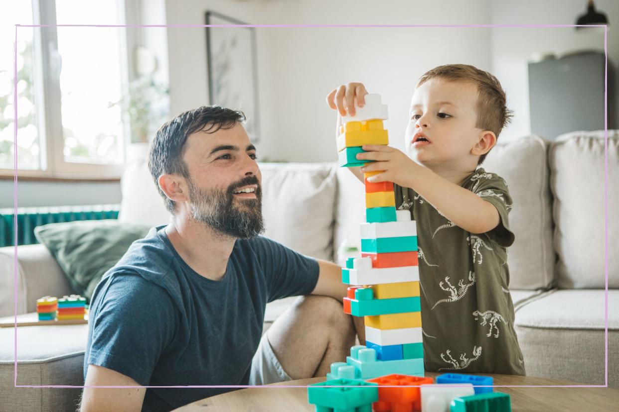  A father and son building a Lego tower together. 