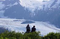 Portage Glacier as seen from Portage Pass, as hikers look on, in Chugach National Forest in Alaska