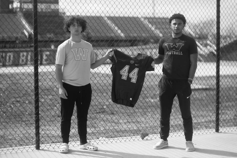 Mason's step-brother Anthony and friend Cory Carl hold his football jersey (Micah McCoy for NBC News)