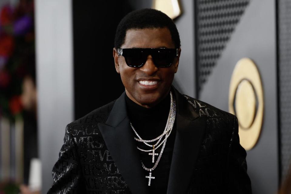 Babyface wears a black blazer, sunglasses and multiple silver cross necklaces