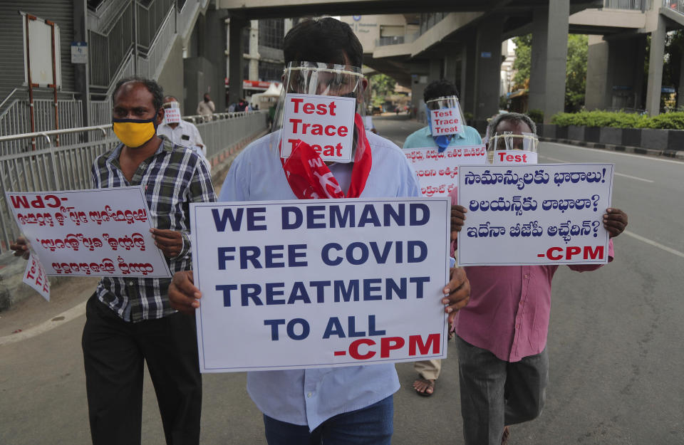 Activists of Communist Party of India Marxist wearing face shields and hold placards during a protest asking the state government to increase testing and free treatment for all COVID-19 patients in Hyderabad, India, Monday, June 29, 2020. Governments are stepping up testing and warily considering their next moves as the number of newly confirmed coronavirus cases surges in many countries. India reported more than 20,000 new infections on Monday. (AP Photo/Mahesh Kumar A.)