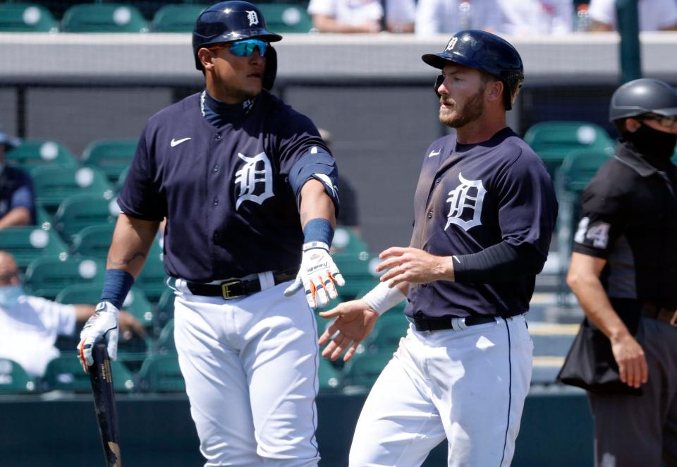 Detroit Tigers outfielder Robbie Grossman, right, is congratulated by Miguel Cabrera as he scores a run during the first inning against the New York Yankees at Joker Marchant Stadium, March 23, 2021 in Lakeland, Fla.