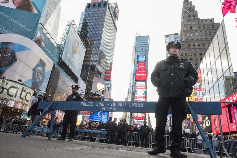 New York City police officers stand guard in Times Square during New Year's Eve celebrations in New York December 31, 2014. REUTERS/Keith Bedford (UNITED STATES - Tags: ANNIVERSARY SOCIETY)