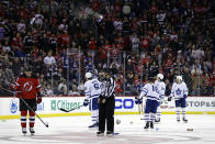 New Jersey Devils defenseman Ryan Graves (33) and Toronto Maple Leafs' John Tavares (91), Mitchell Marner (16) and Auston Matthews (34) avoid flying objects during the third period of an NHL hockey game Wednesday, Nov. 23, 2022, in Newark, N.J. Fans were reacting to a New Jersey Devils goal being disallowed for the third time. The Maple Leafs won 2-1. (AP Photo/Adam Hunger)