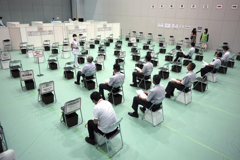 Tokyo Metropolitan Government employees rest after receiving the Moderna's COVID-19 vaccine shot at a newly opened vaccination center at their government building Thursday, July 1, 2021, in Tokyo. The pressure of hosting an Olympics during a still-active pandemic is beginning to show in Japan. While Japan has made remarkable progress to vaccinate its population against COVID-19, the drive is losing steam because of supply shortages.(AP Photo/Eugene Hoshiko)