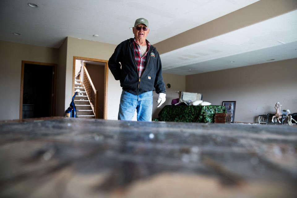 Larry Ehlers looks to a puzzle, made by his late wife, as he cleans the debris from Friday's tornado on Monday, April 29, 2024, in Minden, IA.