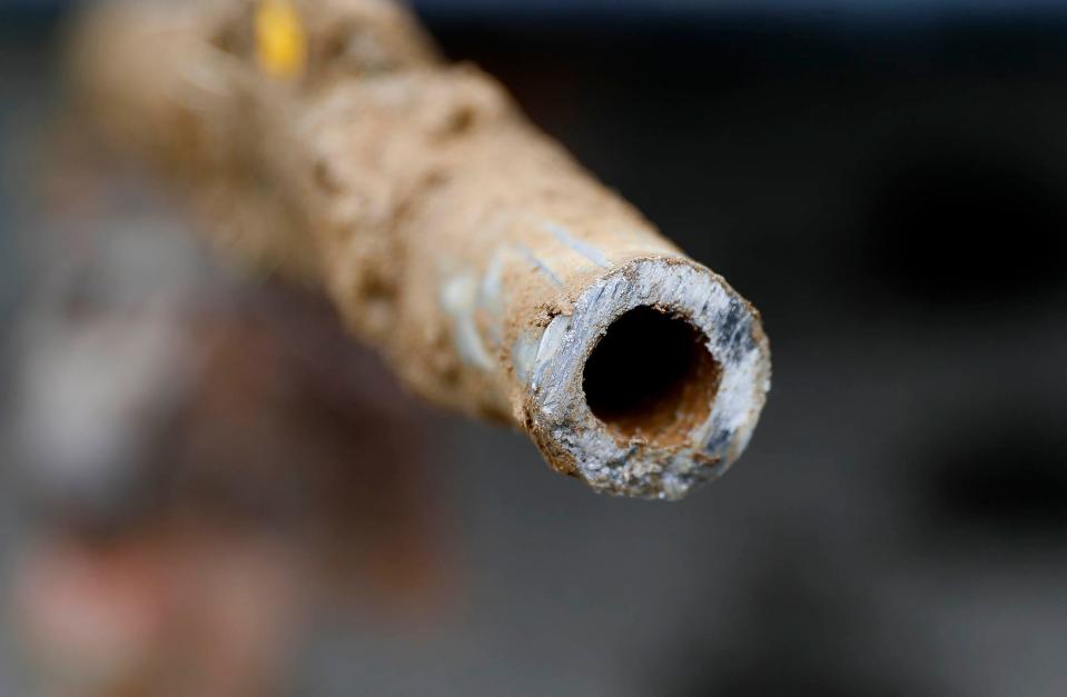 A lead pipe is shown after being replaced by a copper water supply line to a home in Flint, Mich. A federal infrastructure plan, if approved by Congress, would replace lead service lines.