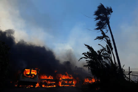 Cars burn along with a home during the Lilac Fire, a fast moving wild fire in Bonsall, California, U.S., December 7, 2017. REUTERS/Mike Blake