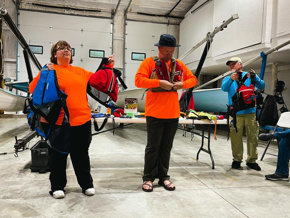 Julie Carey, Todd Wilkinson and Darrel Kerr show different styles of life jackets.