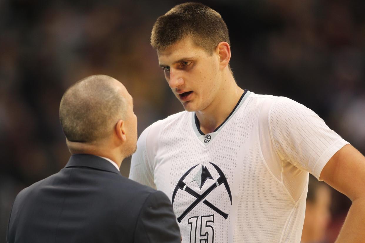 This file photo from Dec. 15, 2016 shows Nuggets coach Michael Malone, left, talking with Nikola Jokic during the first half of a regular-season game at Pepsi Center in Denver.