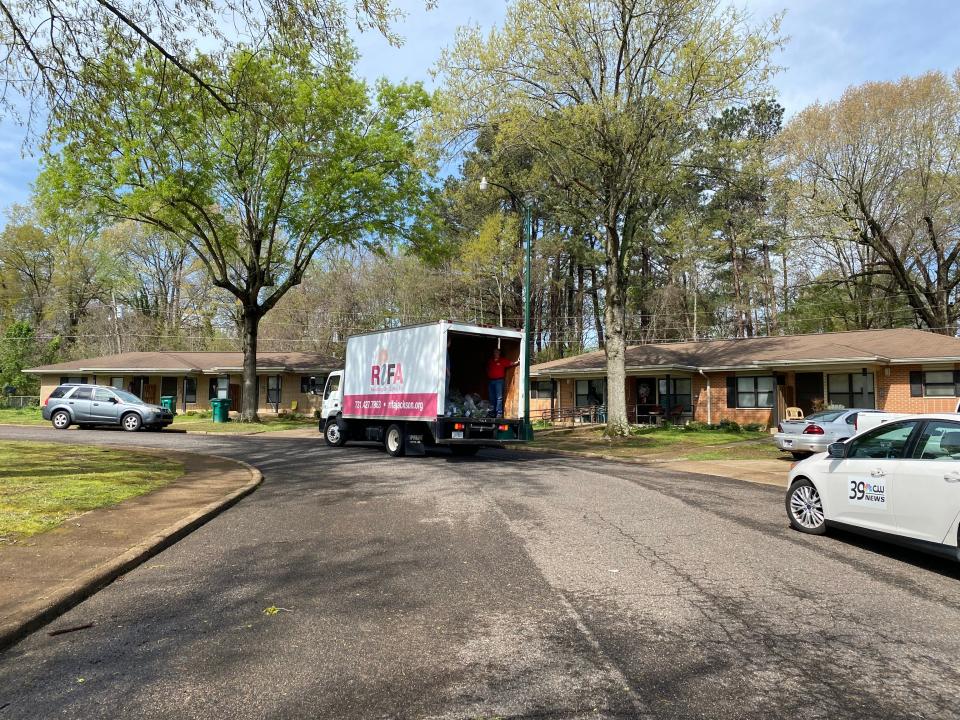 The RIFA truck rolls slowly through the Rosewood neighborhood, dropping off bags of fresh produce to residents.