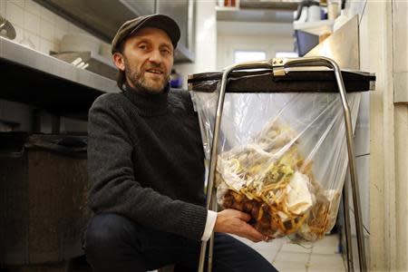 Stephan Martinez, owner of Le Petit Choiseuil bistrot, poses next to food waste garbage in the kitchen of his restaurant in Paris February 12, 2014. REUTERS/Charles Platiau