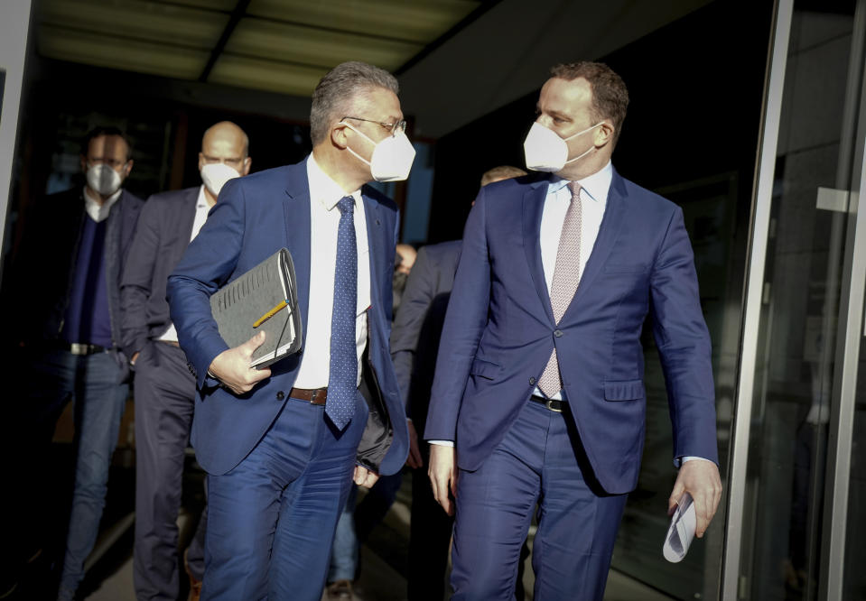 Jens Spahn, Executive Federal Minister of Health, and Lothar H. Wieler, President of the Robert Koch Institute (RKI), from right, leave the Federal Press Conference after a press conference on developments in the Corona pandemic in Berlin, Germany, Friday, Dec. 3, 2021. (Kay Nietfeld/dpa via AP)