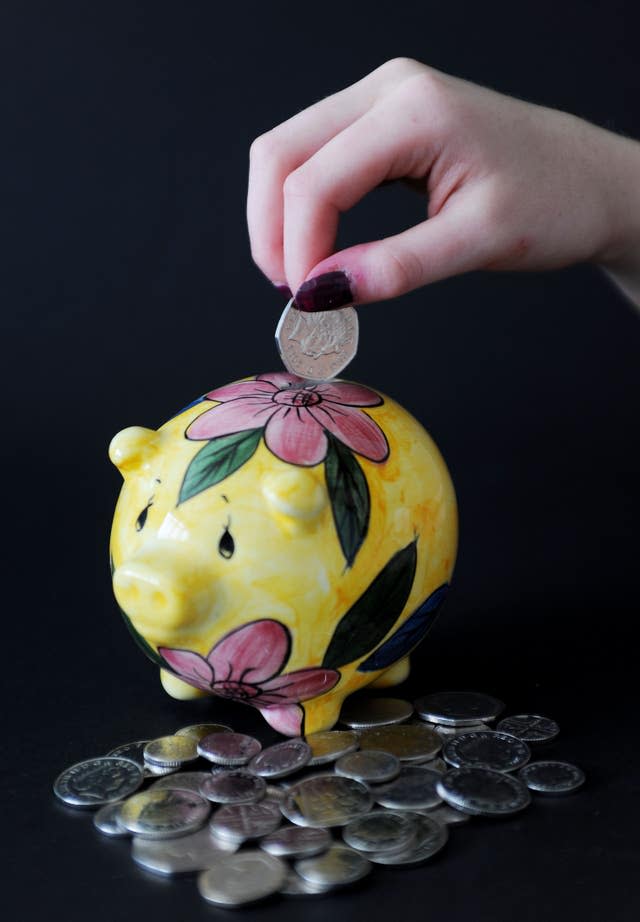 Woman putting coin in piggy bank.