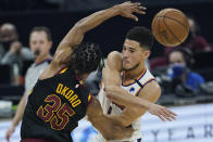 Phoenix Suns' Devin Booker, right, passes against Cleveland Cavaliers' Isaac Okoro in the first half of an NBA basketball game, Tuesday, May 4, 2021, in Cleveland. (AP Photo/Tony Dejak)