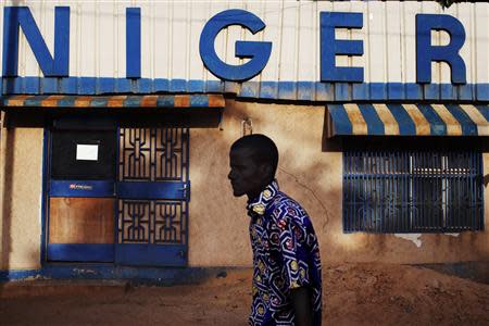 A man walks past a sign reading "Niger" in Niamey, September 13, 2013. REUTERS/Joe Penney