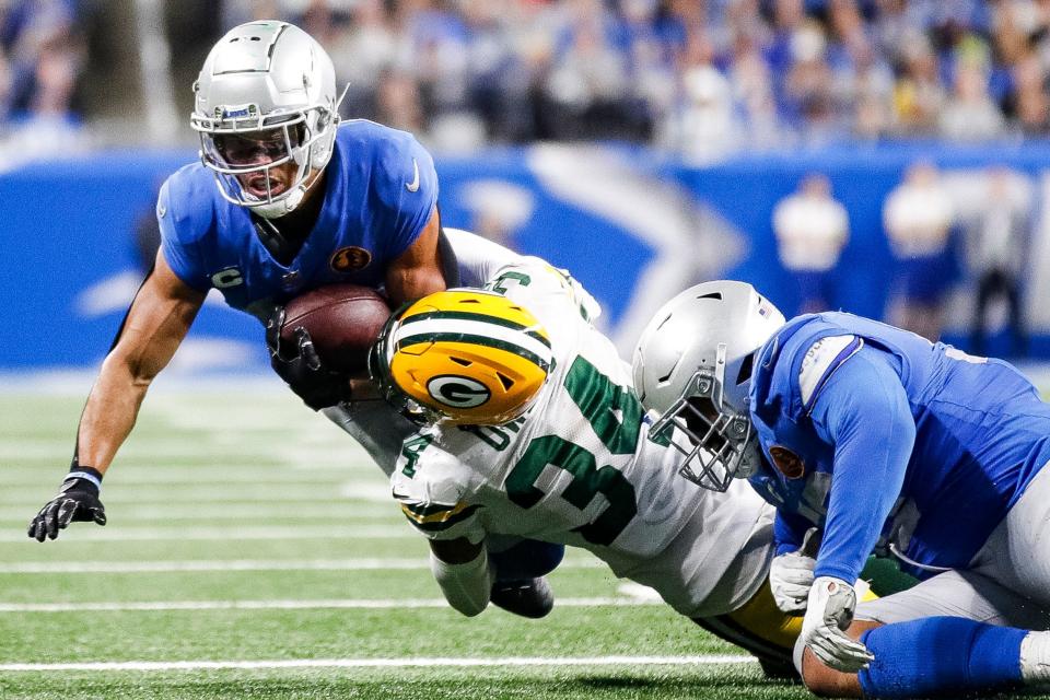 Detroit Lions receiver Amon-Ra St. Brown is tackled by Green Bay Packers safety Jonathan Owens during the second half at Ford Field in Detroit on Thursday, Nov. 23, 2023.