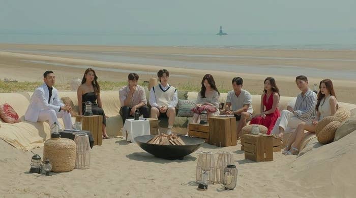 The cast of "Single's Inferno" sits around the fire pit