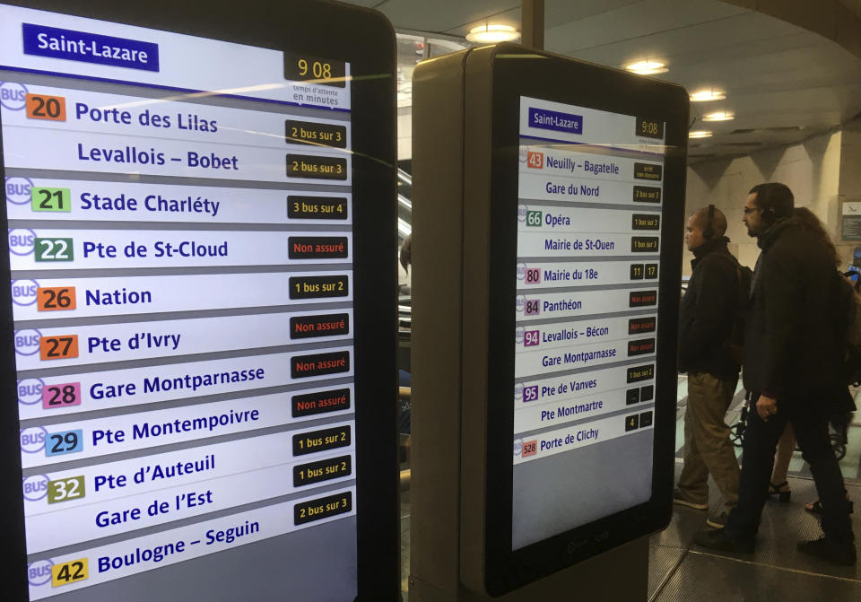 People walk by electronic boards advertising on bus disruptions during a transport strike Friday Sept.13, 2019 in Paris. A massive strike is paralyzing Paris public transports on Friday as unions protest a sweeping pension reform by French President Emmanuel Macron's government. Paris public transport company RATP says 10 metro lines are closed and several others, including the RER suburban rail, are severely disrupted. (AP Photo/Bertrand Combaldieu)