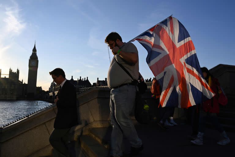 Un hombre con la bandera de la Union Jack mientras avanza en la fila para despedirse de la reina