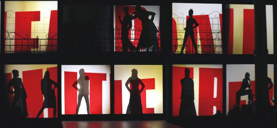 Silhouettes of models behind screens that display the name of French fashion designer Jean-Paul Gaultier as part of his Ready to Wear Fall-Winter 2013-2014 fashion collection, presented, Saturday, March 2, 2013 in Paris. (AP Photo/Jacques Brinon)