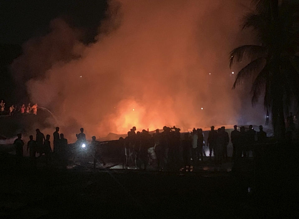 People work to put out a fire in a makeshift market near a Rohingya refugee camp in Kutupalong, Bangladesh, Friday, April 2, 2021. The fire broke out early Friday when residents of the sprawling Kutupalong camp for Myanmar's Rohingya refugees were asleep. (AP Photo/Shafiqur Rahman)