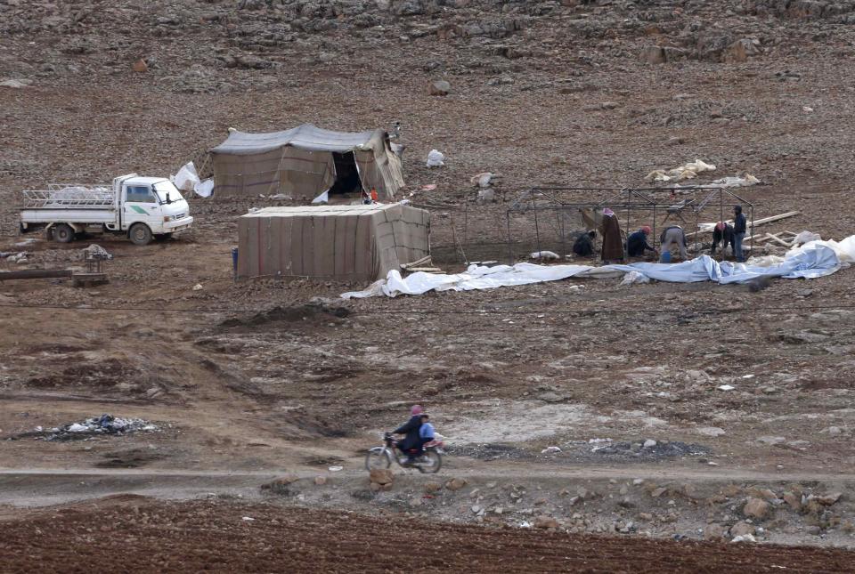 Syrian refugees, who fled the violence from their country, build a tent in preparation for a storm at the Lebanese border town of Arsal, in the eastern Bekaa Valley December 10, 2013. The Social Affairs Ministry announced Tuesday that it started to execute a plan for helping the displaced Syrians in Lebanon amidst the snow storm expected to strike Lebanon today evening, the National News Agency (NNA) reported. REUTERS/Mohamed Azakir (LEBANON - Tags: POLITICS CIVIL UNREST SOCIETY IMMIGRATION CONFLICT)