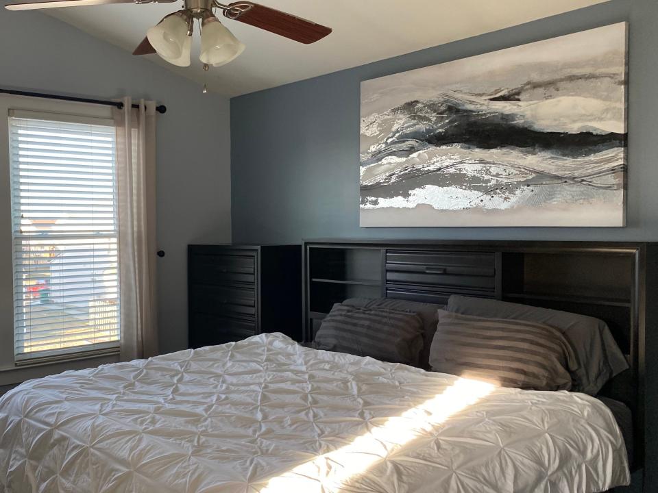 bedroom with artwork above bed frame