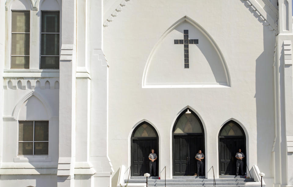 Members of the Charleston County Sheriff's Office guard the front doors of the Emanuel A.M.E. Church during a morning service, Sunday, June 21, 2015, in Charleston, S.C., four days after a mass shooting at the church claimed the lives of its pastor and eight others. (AP Photo/Stephen B. Morton)