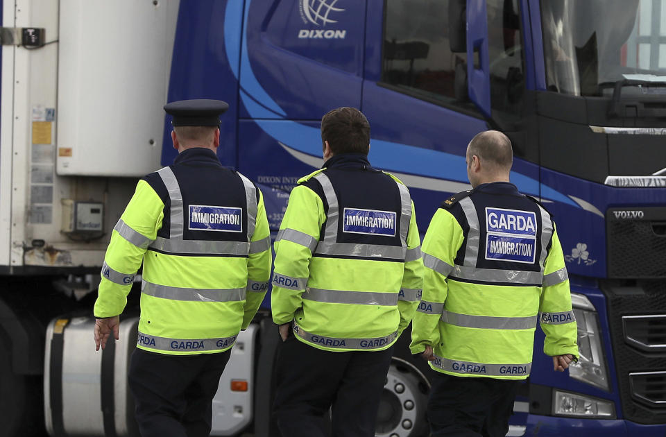 Garda immigration officers at Dublin Port, Ireland, Wednesday Oct. 23, 2019, that is reported to have been the likely exit point for a truck containing 39 people, to journey from Europe to the British ferry port at Holyhead in Wales. Murder investigators are trying to piece together the movements of a large cargo truck found in south-east England on Wednesday, containing the bodies of 39 people in one of Britain’s worst people smuggling tragedies. (Brian Lawless/PA via AP)