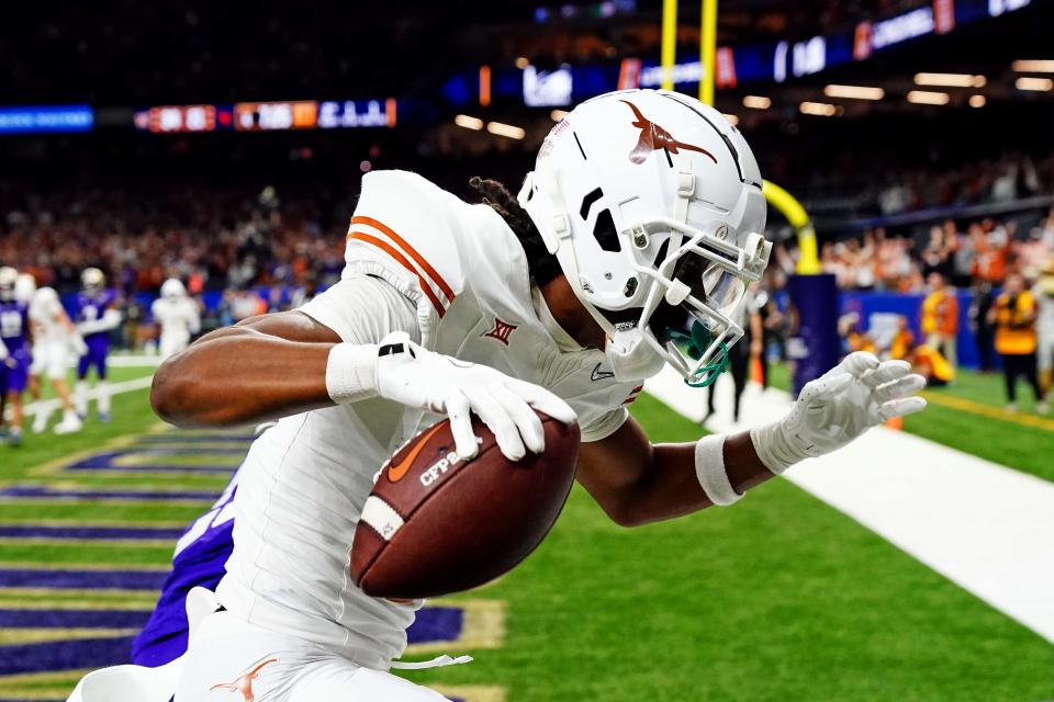 Jan 1, 2024; New Orleans, LA, USA; Texas Longhorns wide receiver Adonai Mitchell (5) catches a touchdown pass against Washington Huskies running back Ryder Bumgarner (25) during the fourth quarter in the 2024 Sugar Bowl college football playoff semifinal game at Caesars Superdome. Mandatory Credit: John David Mercer-USA TODAY Sports