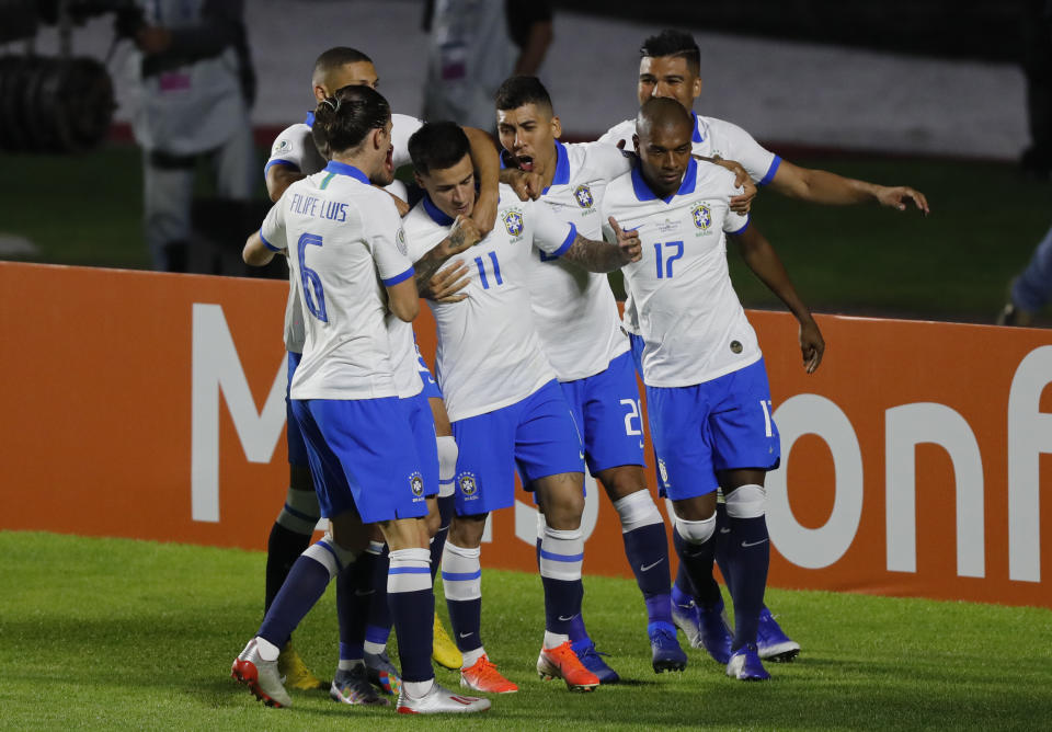 Brazil's Philippe Coutinho, center, celebrates scoring his side's opening goal with teammates during a Copa America Group A soccer match at the Morumbi stadium in Sao Paulo, Brazil, Friday, June 14, 2019. (AP Photo/Nelson Antoine)