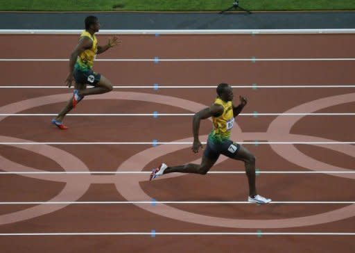 El atleta jamaicano Usain Bolt lidera este jueves la final de 200 metros lisos de los Juegos Olímpicos de Londres, por delante de su compatriota Yohan Blake, antes de ganar la medalla de oro. (AFP | Thomas Coex)