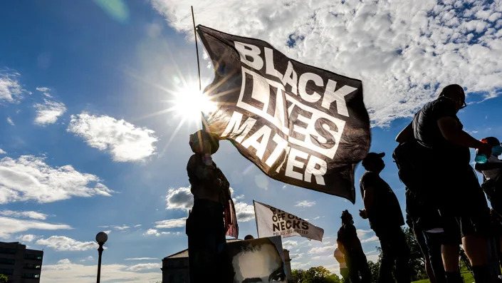 A woman holds a Black Lives Matter flag during an event in remembrance of George Floyd and to call for justice for those who lost loved ones to police violence outside the Minnesota State Capitol May 24, 2021, in Saint Paul, Minn. <span class="copyright">Kerem Yucel / AFP via Getty Images</span>