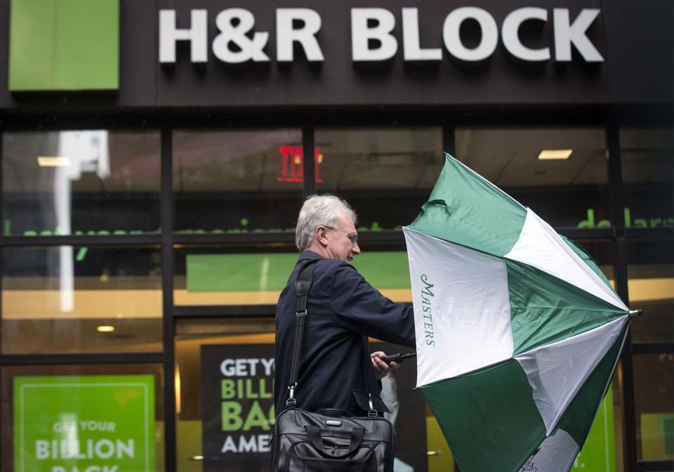 A man arrives at an H&R Block tax center in New York April 15, 2014. April 15 is the deadline for Americans to file their taxes with the IRS. REUTERS/Brendan McDermid (UNITED STATESBUSINESS – Tags: BUSINESS POLITICS)