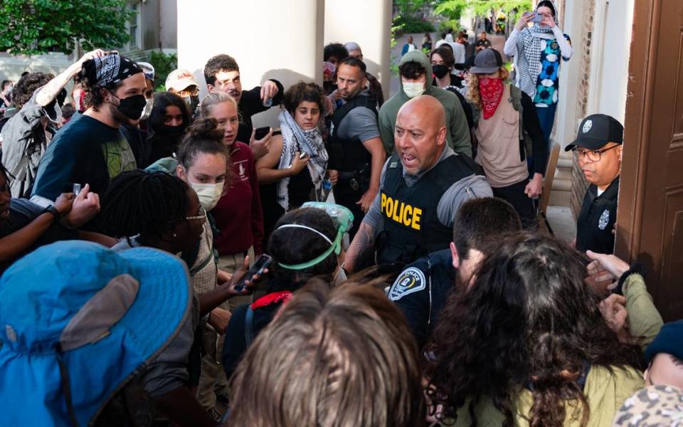 Police confront protesters outside of South Building on the UNC campus in attempts to move protestors away from the doors on Tuesday, April 30.