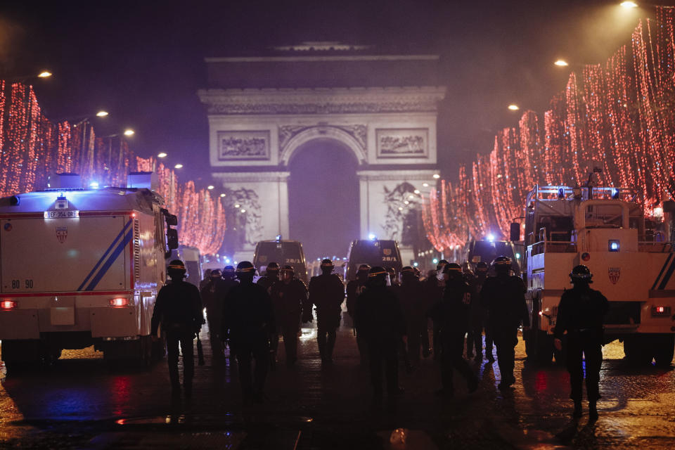 Riot police officers are seen on the Champs Elysees avenue with the Arc de Triomphe in the background, during a demonstration, in Paris Saturday, Dec. 22, 2018. France's yellow vest protesters, who have brought chaos to Paris over the past few weeks with their economic demands, demonstrated in sharply reduced numbers Saturday at the start of the Christmas and New Year holidays. (AP Photo/Kamil Zihnioglu)