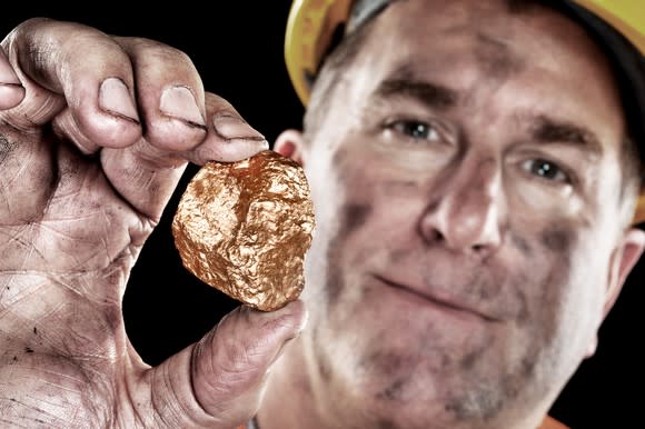 A miner holding a gold nugget