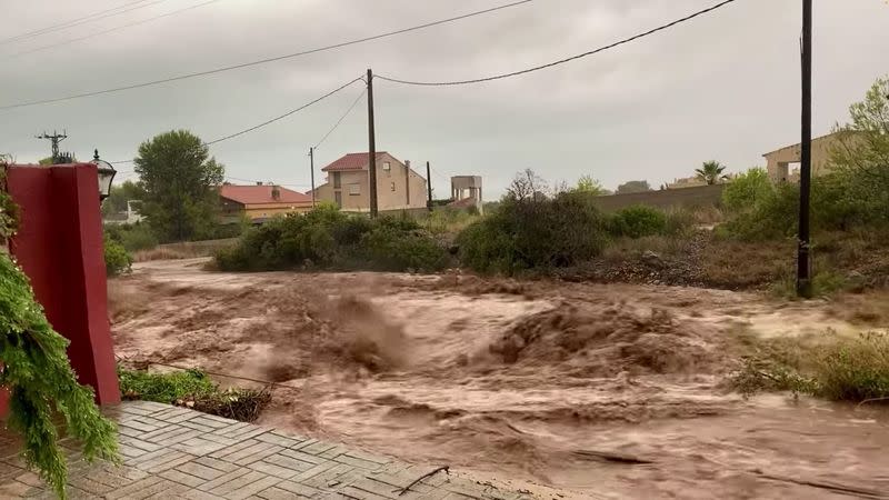 Torrents of floodwater rush next to homes in Alcanar